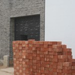 Bricks stacked outside the entrance to Mr. He's studio