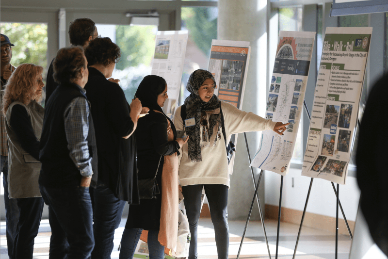 A student presents their research on a poster