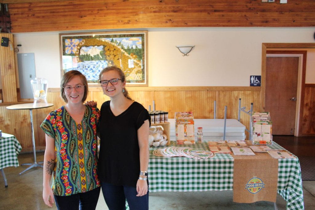 Author and fellow RARE member standing close together in front of a Food Hero display table
