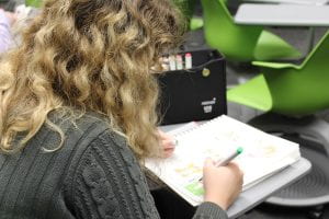 student drawing comic book in classroom