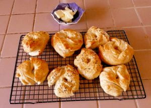 bagels on a cooling rack with a small bowl of butter above