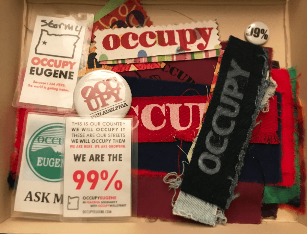 Buttons, pins, name badges related to Occupy Eugene