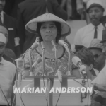 Marian Anderson stands at a podium with several microphones.